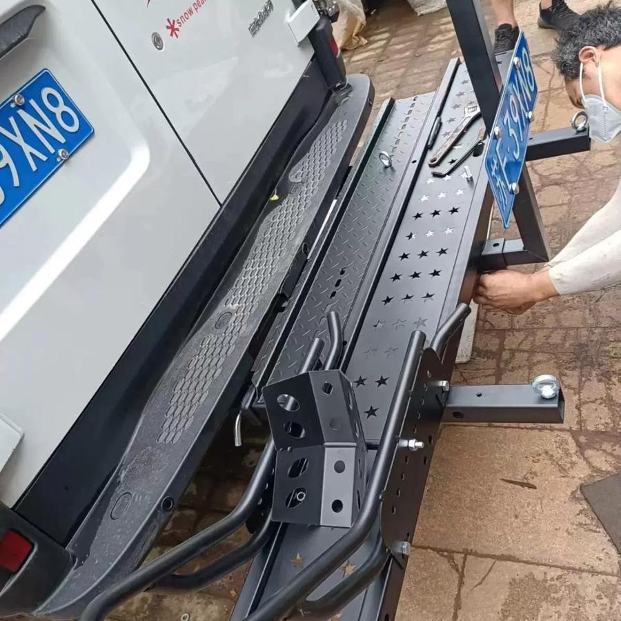 Close-up of motorcycle carrier mounted on a vehicle showing wheel chock and tie-down points